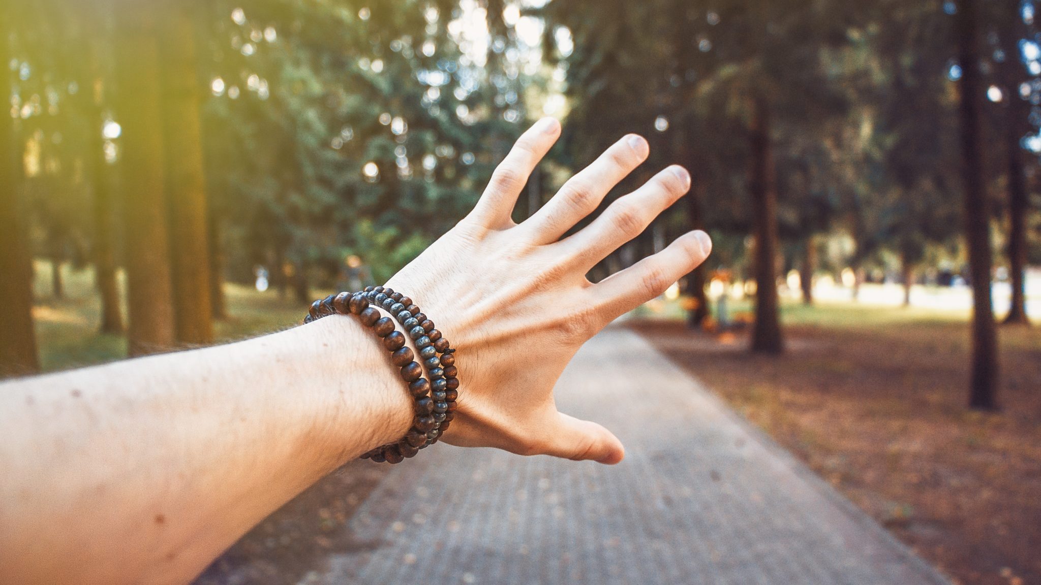 man holding out hand with bracelets